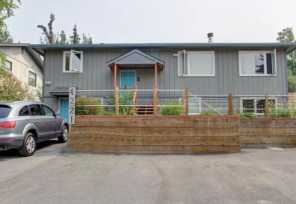 A two-story building with a grey exterior, a blue door, and a small porch area. - Upper Grape, Midtown Home 2bed&1bath (Anchorage)