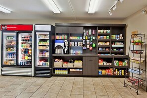 Un angolo dedicato alle bevande self-service, con distributori di Coca-Cola e una selezione di snack e bevande.