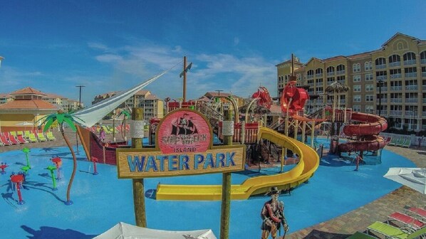 Un parc aquatique avec une enseigne indiquant « Parc aquatique » et une statue sur le thème des pirates.