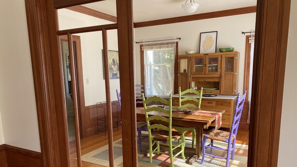 Un coin repas avec des meubles en bois, un tapis et un buffet aux portes vitrées.