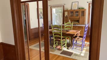 A dining area with wooden furniture, a rug, and a cabinet with glass doors.