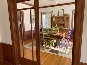 A dining area with wooden furniture, a rug, and a cabinet with glass doors.
