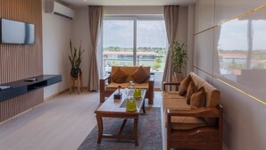 A modern living room with a sofa, a coffee table, and a TV mounted on the wall. - Lumbini Green Resort (Shivaraj)