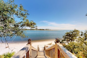 Walk along the boardwalk to the sandy beach surrounded by lush greenery.