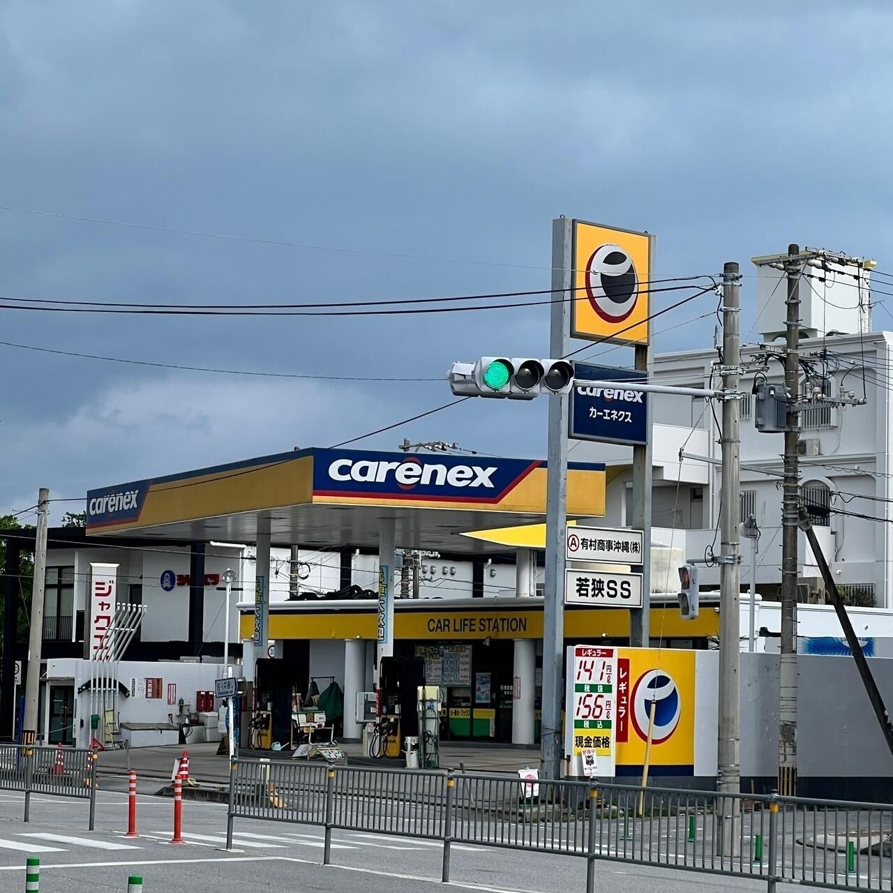 Una estación de servicio Carenex con una estación de servicios para automóviles, un semáforo y una señal de prohibido estacionar.