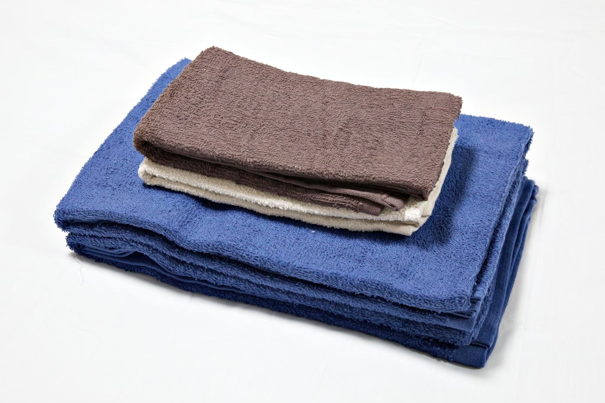 A stack of folded towels in blue and brown colors.