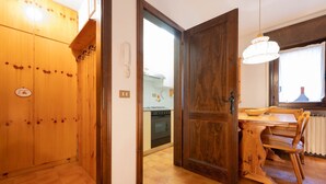 Een houten interieur, met een keuken die zichtbaar is door een open deur.