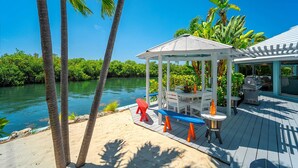 A wooden deck with a gazebo, a pool, and a view of a river. - Poseidon's Paradise: Luxury Waterfront Rental in Key West, Stunning Backyard Oasis and Private Pool! (Key West)