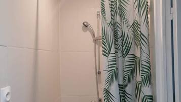 Een douche, handdoeken, zeep, toiletpapier