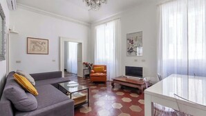 Una sala de estar moderna con un sofá, una mesa de centro, un televisor y una mesa de comedor.