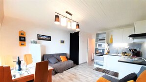 Een modern appartement met een eethoek, een bank en een keuken.