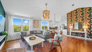 A modern living room with a sectional sofa, a dining area, and a kitchen. - Ciel - Endless Holiday Stays! (St. Augustine Beach)