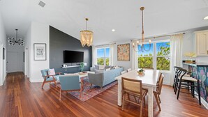 A spacious living area with a dining table, sofas, and a TV. - Ciel - Endless Holiday Stays! (St. Augustine Beach)