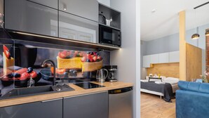 A modern kitchen with a dishwasher, a microwave, and a large island with a sink. - Comfortable Studio | Workspace | Close to the Marketplace (Kraków)