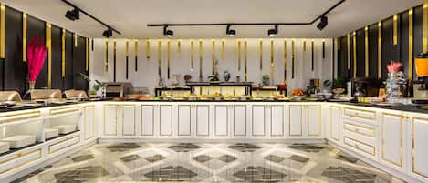 A modern kitchen with white cabinetry, black and gold accents, and a geometric marble floor.