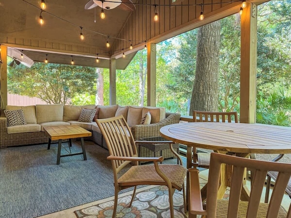 Un espace extérieur aménagé, abrité et doté d’un canapé, de chaises et d’une table.