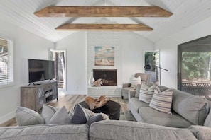 A living room with a fireplace, a television, and a sofa.
