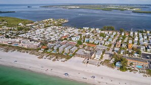 Vista aérea de una zona residencial costera con casas, una playa y un puerto deportivo.