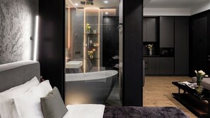 A modern bathroom with a freestanding bathtub, a glass-enclosed shower, and a vanity with a mirror. - Stay Inn  on Buzand Str. 97 (Yerevan)