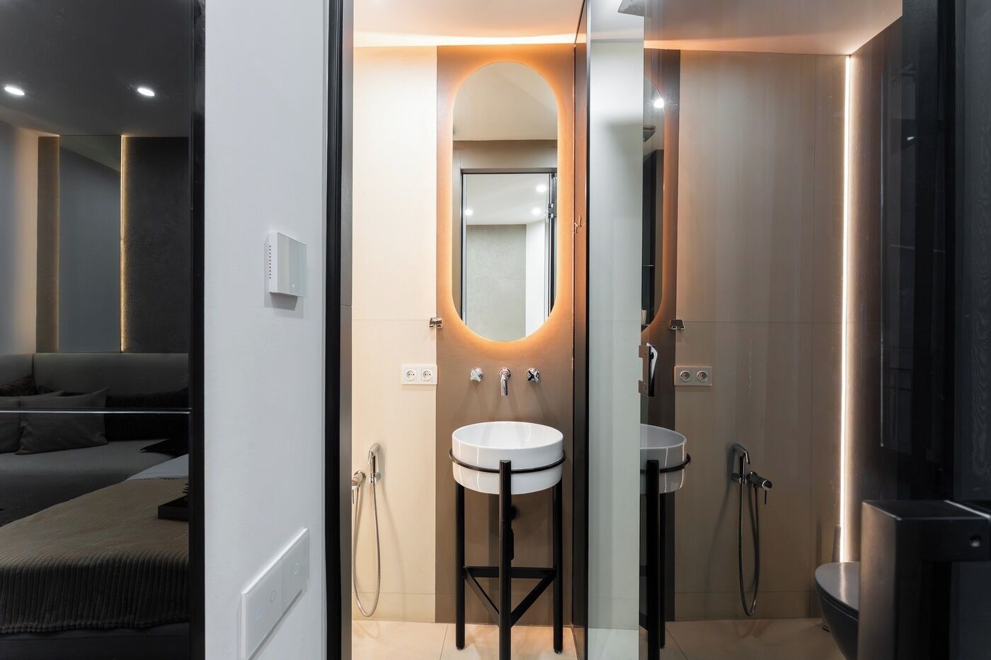 A modern bathroom with a vanity, a mirror, and a shower area.