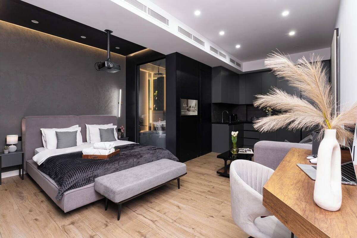 Een moderne slaapkamer met een bed, nachtkastje en een bureau met een stoel.