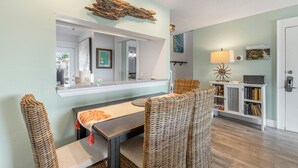 A dining area with a table, chairs, a mirror, and a bookshelf. - Inlet Beach + Gulf View, Pet Friendly & Bikes (Inlet Beach)