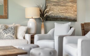 A living room with a sofa, armchair, ottoman, lamp, vase, and a painting on the wall. - Inlet Beach + Gulf View, Pet Friendly & Bikes (Inlet Beach)