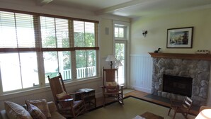 A cozy living room with a stone fireplace, a sofa, a coffee table, and a chair.