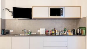 A modern kitchen with a built-in microwave, a flat-screen TV, and a variety of kitchen appliances and utensils. - Apartment "Annabel" with Mountain View, French Balcony & Wi-Fi (Bolzano)