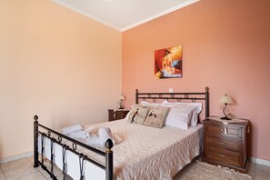 Une chambre à coucher avec un lit, des tables de chevet, une commode et un tableau au mur.