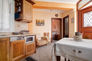 Une cuisine dotée de meubles en bois, d’un lave-vaisselle, d’un four et d’un coin repas avec une table et des chaises.