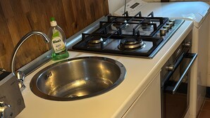 A kitchen with a stainless steel sink, a gas stove, and a built-in oven. - Holiday Home "Seroa 1" with Sea View, Shared Terrace and Wi-Fi (Vernazza SP)