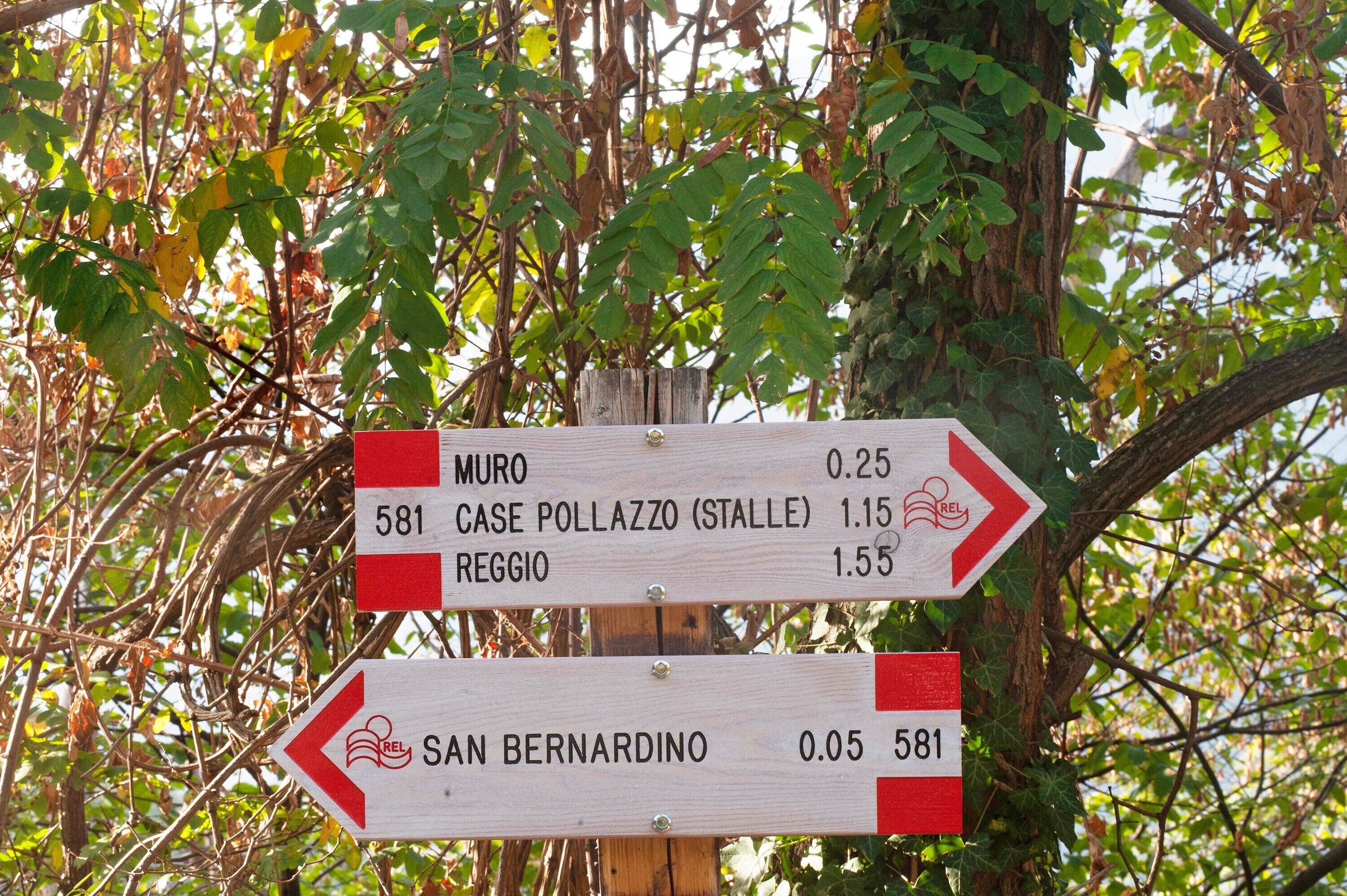 Un cartello direzionale con indicazioni di destinazione e distanze.