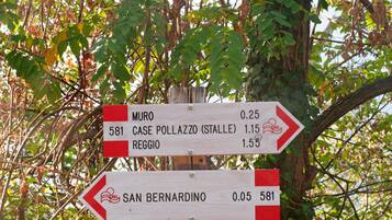 Un cartello direzionale con indicazioni di destinazione e distanze.