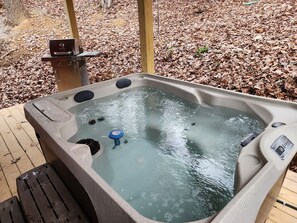 A hot tub with a control panel and a wooden deck.