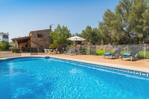 A swimming pool with lounge chairs and a stone building in the background. - Vacation Home "Lletreres" with Private Terraces, Private Pool & Wi-Fi (Llubi)