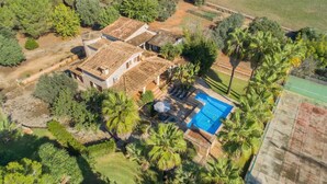 A large house with a swimming pool, surrounded by palm trees and a tennis court. - Vacation Home "Tirasset" with Private Pool, 2 Terraces & Wi-Fi (Llubi)