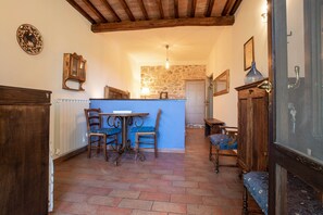 Un intérieur rustique avec un mur en pierre, des meubles en bois et un sol carrelé.