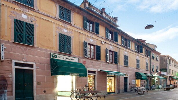 Calle con edificios, una bicicleta y un banco.