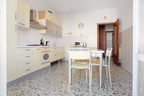 A compact kitchen with a dining area, a microwave, and a sink.