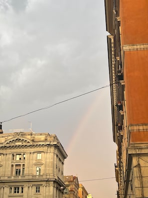 Un edificio de arquitectura clásica, una línea eléctrica visible y un arcoíris en el cielo.
