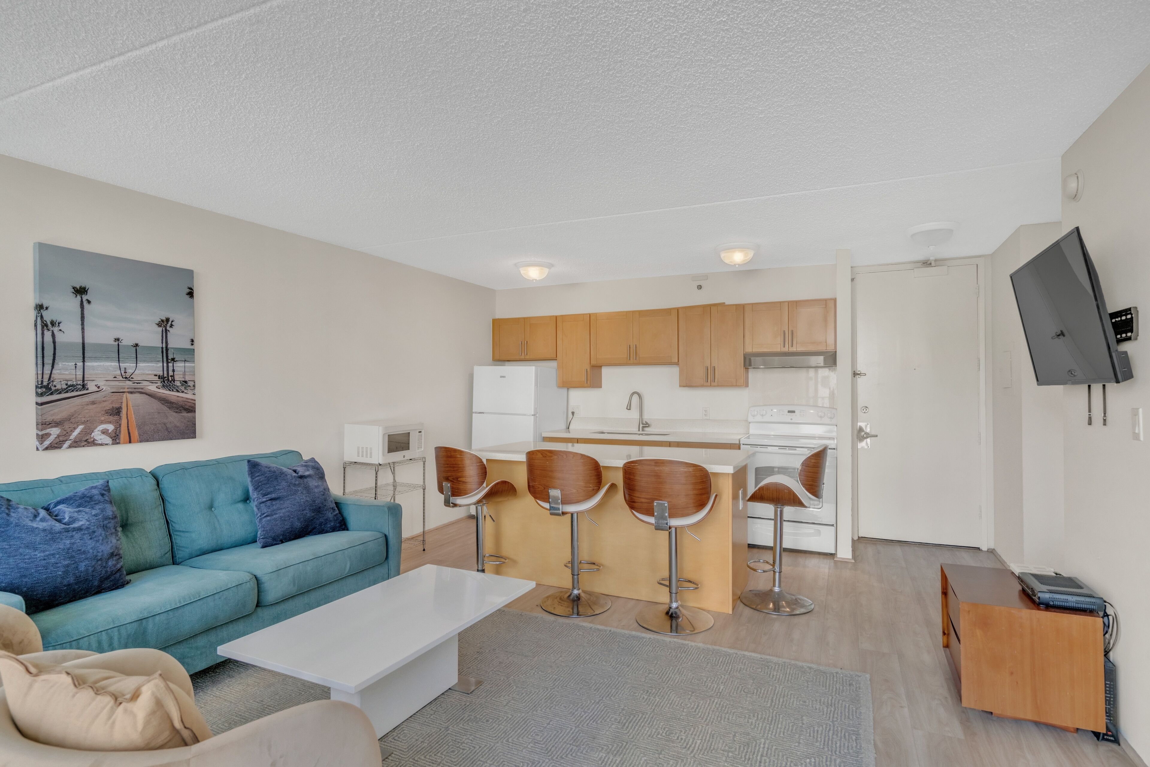 A modern apartment with a living area, kitchenette, and a dining space.
