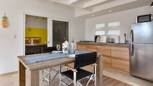 Eine moderne Küche mit einem Holzesstisch, einem Edelstahlkühlschrank und einem eingebauten Backofen.