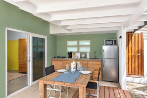 A modern kitchen with a dining area, a refrigerator, and a microwave.