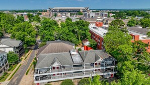 A multi-story building with a flat roof and a balcony on the second floor. - Crimson Court - Book Now for Football! (Tuscaloosa)