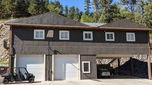 Un bâtiment à deux étages avec un garage et un petit véhicule garé devant.