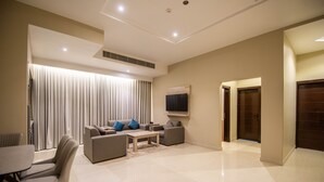 A modern living room with a sofa set, a coffee table, and a TV mounted on the wall. - Granada Palace Inn (Riyadh)