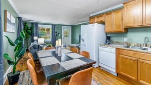A compact kitchen with wooden cabinets, a white refrigerator, and a granite countertop.