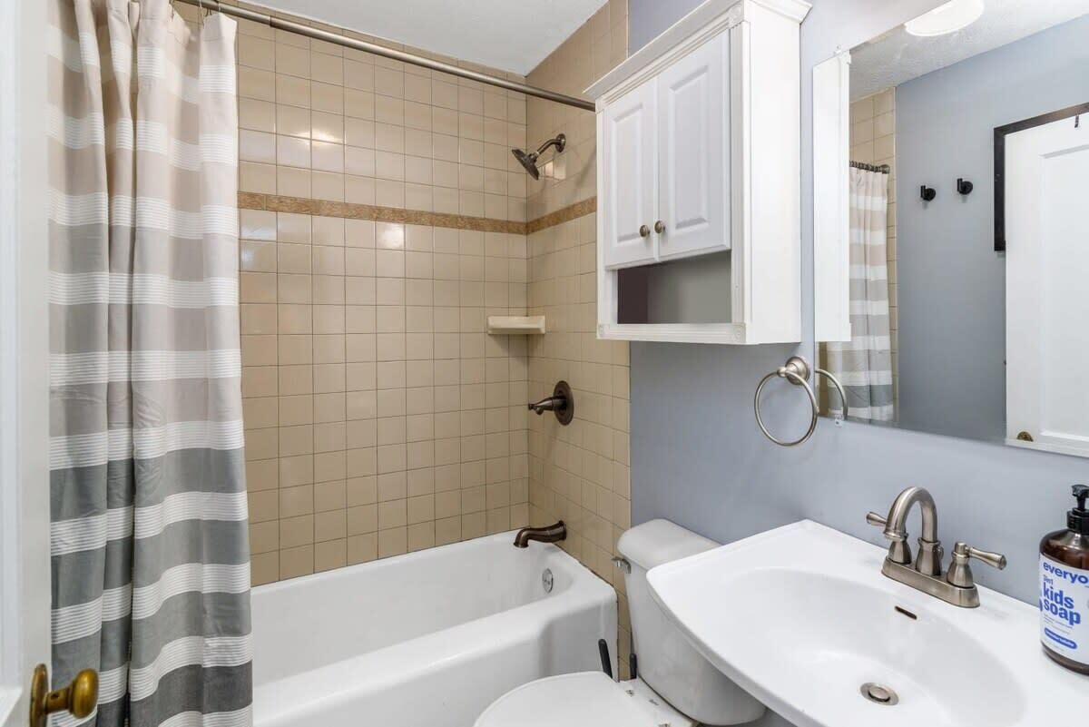 Bathtub, hair dryer, towels, shampoo