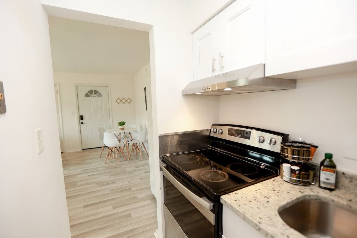 A modern kitchen with a black stove, stainless steel cabinets, and a countertop with a sink.